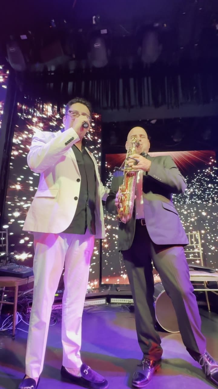 Lazar Barayev performing live on stage with a musician